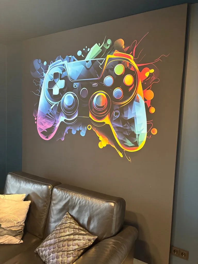 Akoestisch wandframe met een full colour doek van een gamecontroller boven een leren bank