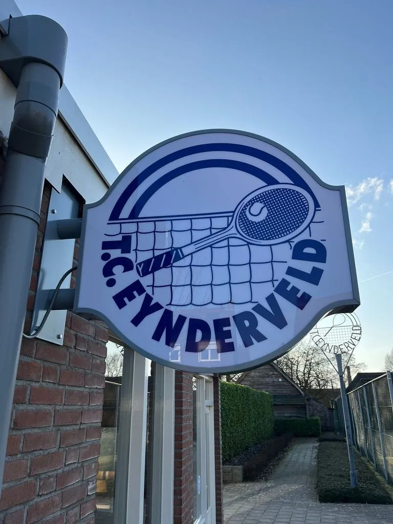 Rond clubbord van tennisclub TC Eynderveld aan de gevel