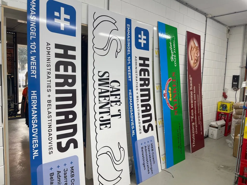 Rij lange reclameborden in de werkplaats, klaar om op te halen
