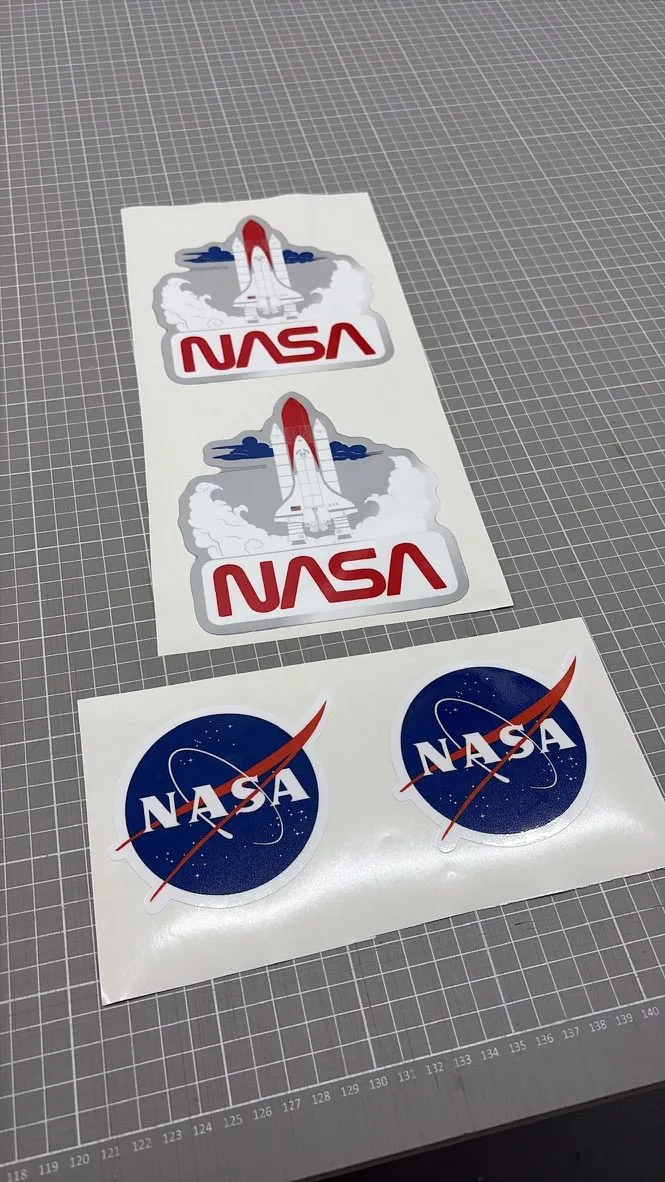 Stickers met het NASA-logo en de spaceshuttle op een snijmat