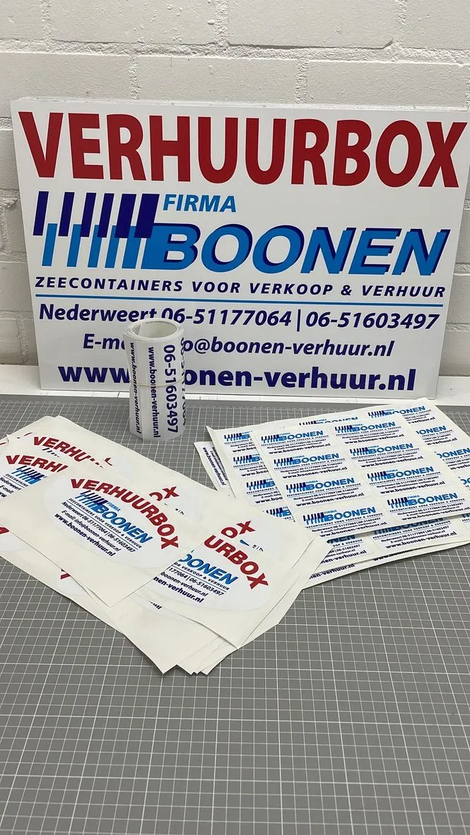 Bord en stapel stickers voor de verhuurboxen van Firma Boonen